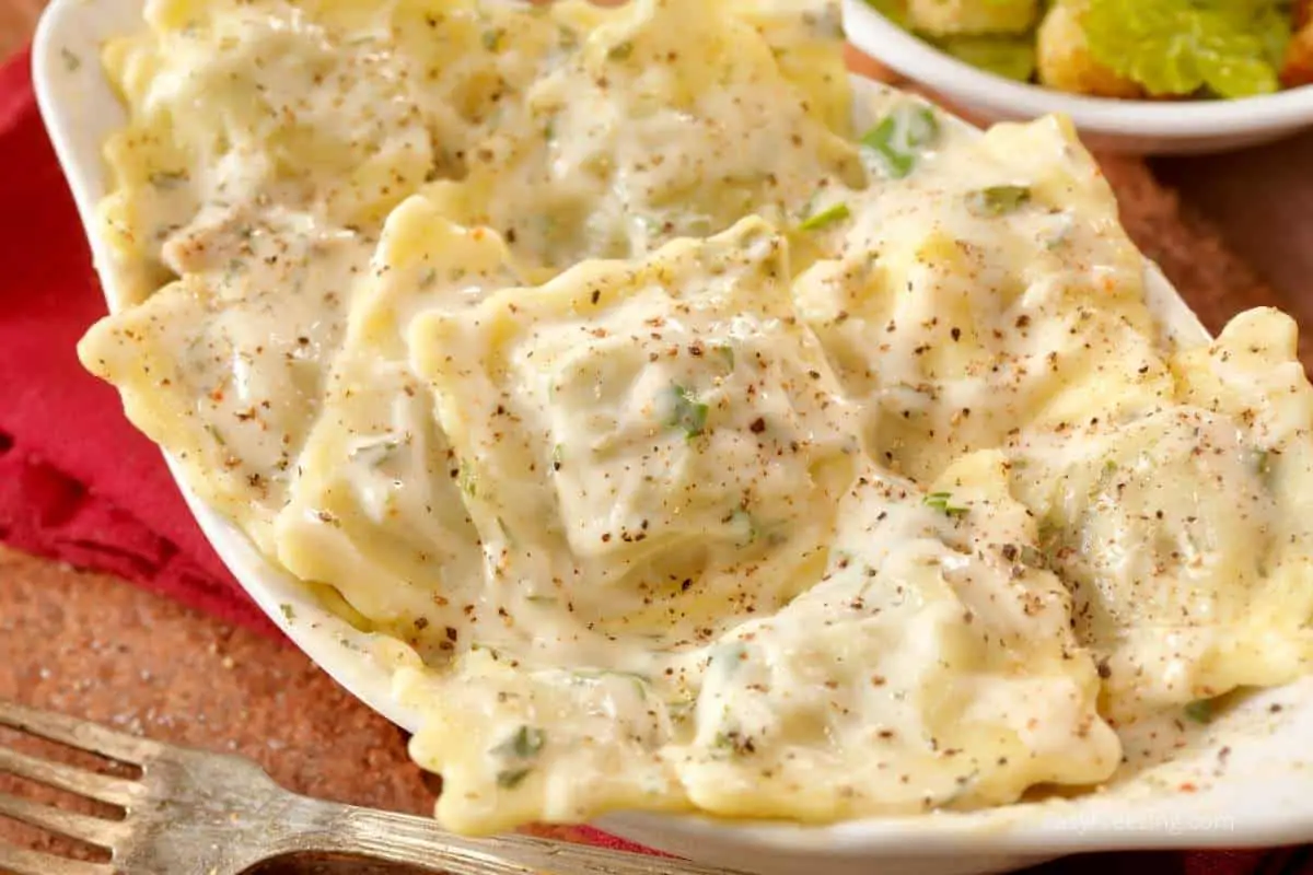 White Alfredo sauce on ravioli.