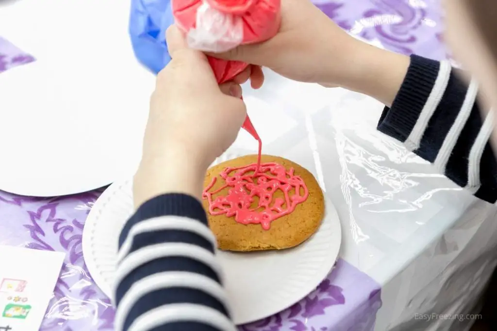 Child frosting a cookie with icing